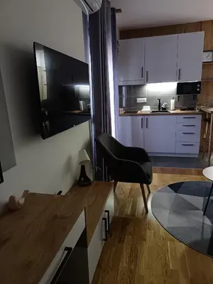 a kitchen with a black chair and a table at Orca Apartman in Jagodina