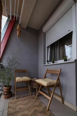 a patio with two chairs and a table and a window at Nana in Pirot