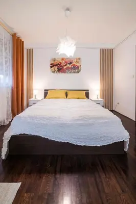 a bedroom with a large bed and two lamps at Nana in Pirot