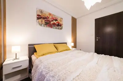 a bedroom with a large bed with a yellow pillow at Nana in Pirot