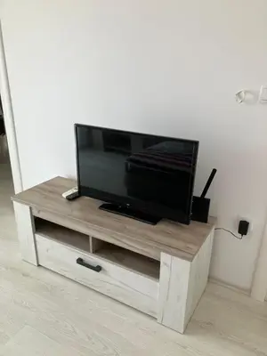 a flat screen tv sitting on top of a wooden entertainment center at Harmony Relax in Paraćin