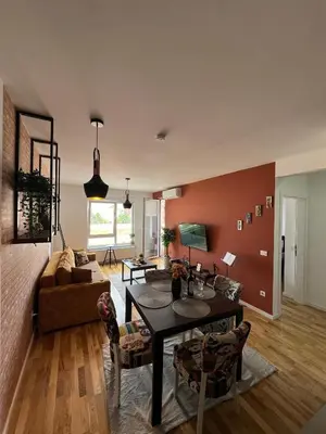 a living room with a table and a couch at Lux apartment 8, center, free parking in Niš