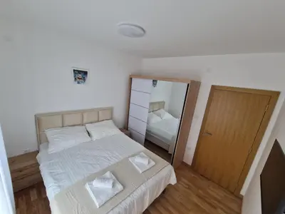 a small bedroom with a bed and a mirror at Nina Apartman 3 in Soko Banja