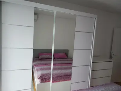a bedroom with a bed and a white closet at Apartman Vera in Vrnjačka Banja