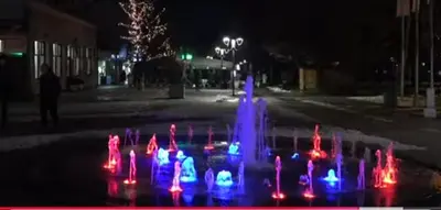a water fountain in the middle of a street at night at Apartman Vera in Vrnjačka Banja
