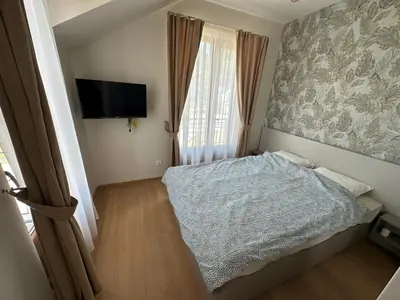 a small bedroom with a bed and a flat screen tv at Royal King in Vrnjačka Banja