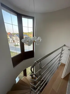 a winding staircase with a window and a chandelier at Royal King in Vrnjačka Banja