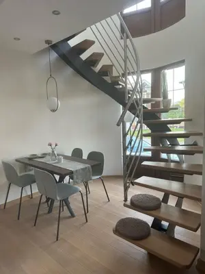 a dining room with a spiral staircase and a table and chairs at Royal King in Vrnjačka Banja