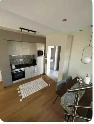 a kitchen and a living room with a table and chairs at Royal King in Vrnjačka Banja