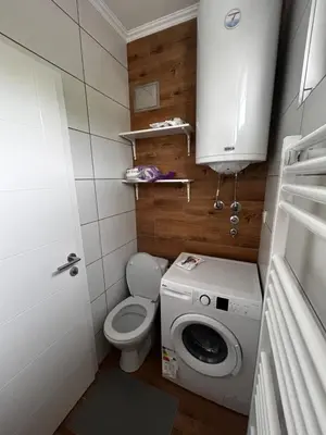 a small bathroom with a toilet and a washing machine at Royal King in Vrnjačka Banja
