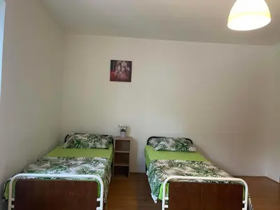 a room with two beds and a table in it at Hostel Drenak in Gornje Rataje