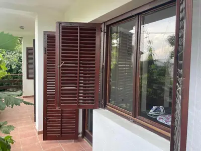 a window with wooden shutters on a house at Hostel Drenak in Gornje Rataje