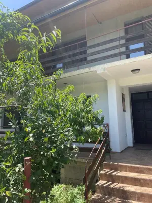 a house with a staircase leading to the front door at Hostel Drenak in Gornje Rataje