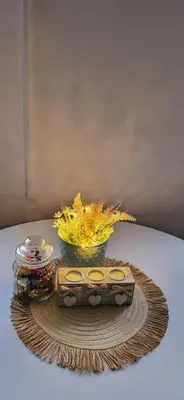 a table with a wooden box and a bowl of flowers at Apartman Marta in Vrnjačka Banja