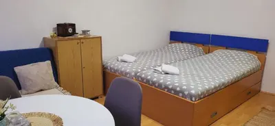 two twin beds in a room with a table at Apartman Marta in Vrnjačka Banja