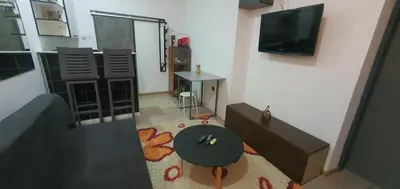 a living room with a table and a tv at Calipso1 in Niš
