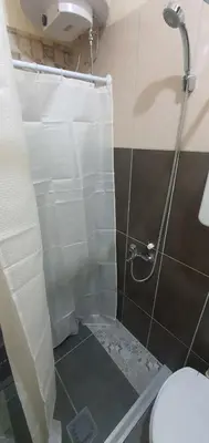 a bathroom with a shower curtain and a toilet at Calipso1 in Niš