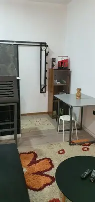 a living room with a table and a table and a rug at Calipso1 in Niš