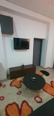 a room with a table and a television on a wall at Calipso1 in Niš