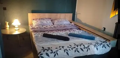 a bed with two pillows on it with a table at Calipso1 in Niš