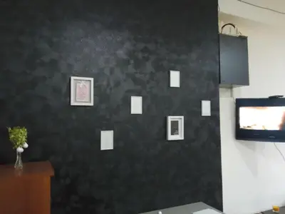 a room with a black wall with pictures on it at Calipso1 in Niš
