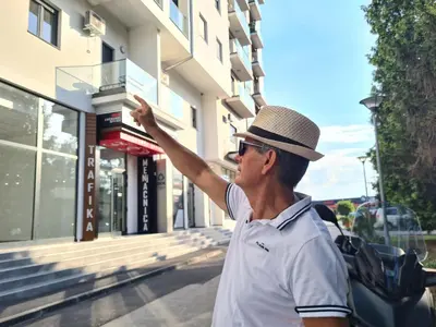 a man wearing a hat standing in front of a building at Apartment Esperanto next to the Aqua Park in Jagodina