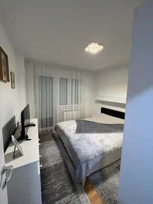 a bedroom with a bed and a desk with a computer at Loft Luxury Apartment in Pirot