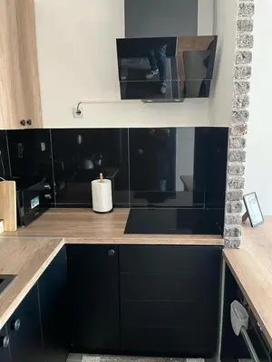a kitchen with black cabinets and a counter top at Loft Luxury Apartment in Pirot