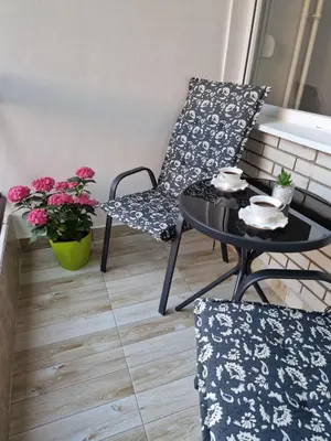 a small balcony with a table and chairs and flowers at Esperanto in Vranje