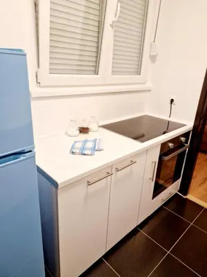 a white kitchen with a sink and a refrigerator at Esperanto in Vranje