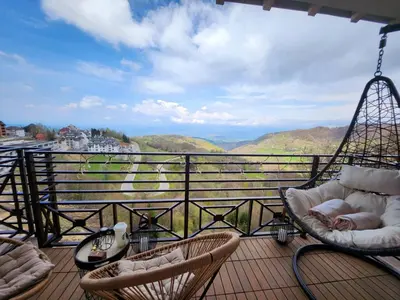 a balcony with chairs and a view of the mountains at Mon réve Nlux79 in Kopaonik