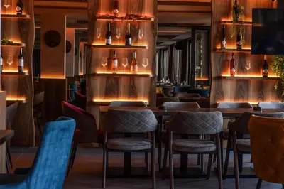 a restaurant with wooden tables and chairs and lights at Mon réve Nlux79 in Kopaonik