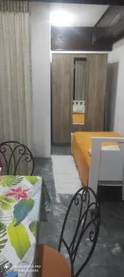 a room with two beds and a table and chairs at LENA Apartman 45m2 Sokobanja-CENTAR in Soko Banja