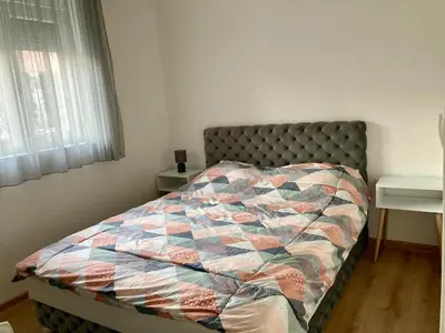 a bed with a quilt on it in a bedroom at SANI in Vrnjci