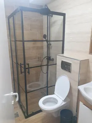 a bathroom with a toilet with a glass shower stall at SANI in Vrnjci