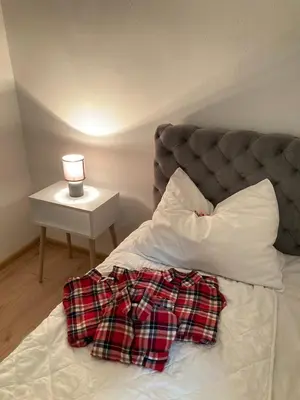 a bed with a pillow and a lamp on a table at SANI in Vrnjci