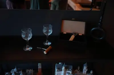 a table with two wine glasses and a box at Diamond Apartments Niš in Niš