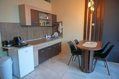 a kitchen with a table and a small table and chairs at Diamond Apartments Niš in Niš