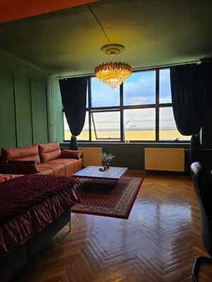 a living room with a couch and a chandelier at Diamond Apartments Niš in Niš