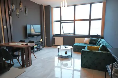 a living room with a couch and a table at Diamond Apartments Niš in Niš