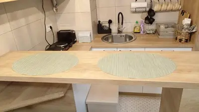 a kitchen with a wooden counter with two mats on it at Apartman Mijatovic in Jagodina