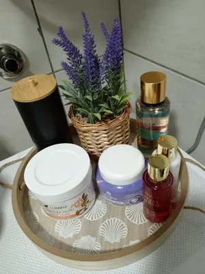 a glass table with a tray with cosmetics and a plant at Apartman Mijatovic in Jagodina