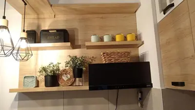 a living room with wooden shelves and a flat screen tv at Apartman Mijatovic in Jagodina