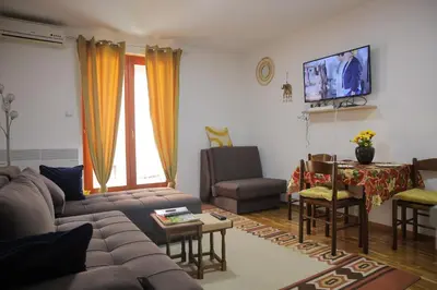 a living room with a couch and a table at Zlatni apartman in Vrnjačka Banja