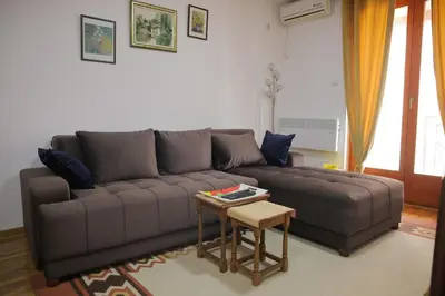 a living room with a brown couch and a table at Zlatni apartman in Vrnjačka Banja