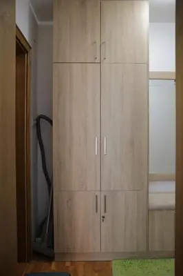 a large wooden cabinet in a room at Zlatni apartman in Vrnjačka Banja