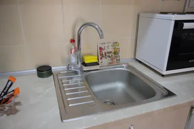 a kitchen sink with a faucet next to a microwave at Zlatni apartman in Vrnjačka Banja