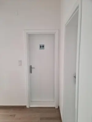 a white door with a sign on it in a room at Apartmani Zvezdana in Vrnjačka Banja