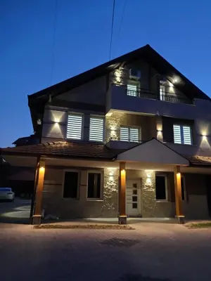 a large house with lights on the front of it at Apartmani Zvezdana in Vrnjačka Banja