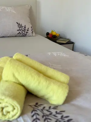 a yellow towel sitting on top of a bed at Apartmani Zvezdana in Vrnjačka Banja